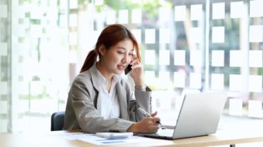 Telefonda konuşan Asyalı bir kadın, bir girişim şirketinde satış elemanı, ürün ve promosyon satmak için müşterileri arıyor. Telefon kanallarından ürün satma kavramı. 4K.