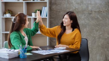 Keyif veren ve laptoplarındaki verilere bakan iki kadın, satış hedeflerini aşan ve kârlı bir büyüme sağlayan aylık satış özetine bakan iki iş kadını. Satış yönetimi kavramı