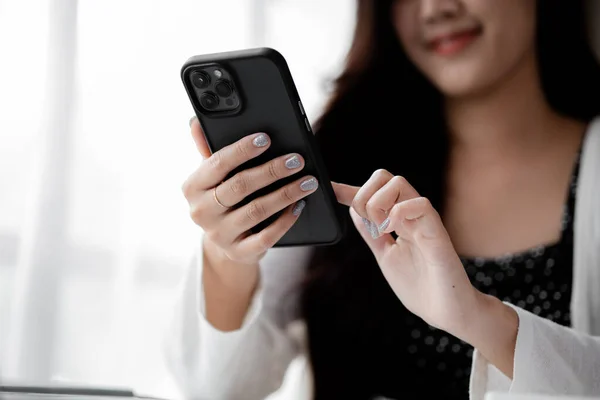 young businesswoman looking at financial information from a mobile phone, she is checking company financial documents, she is a female executive of a startup company. Concept of financial management.