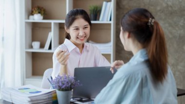 Güzel Asyalı kadın şirket ofisinde iş arkadaşıyla sohbet ediyor, iş kadını işletme yönetimi, planlama toplantısı için departmanda ekip olarak çalışıyor. Çalışan kadın konsepti.