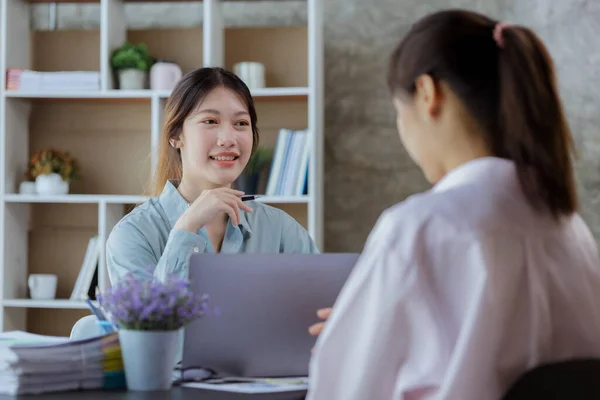 Close up beautiful Asian woman chatting with colleagues in company office, businesswoman operating company administration, staff working as a team in department. Working women concept.