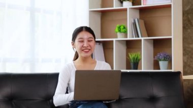 Oturma odasındaki kanepede dizüstü bilgisayar oynayan bir kadın, hafta sonları sıkı çalıştıktan sonra dinleniyor, film izleyerek, müzik dinleyerek ve ailesiyle tablette video dinleyerek rahatlıyor..