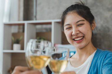Beyaz şarap bardaklarını tokuşturan genç Asyalılar, yeni yıl partileri, yıllık şirket partileri, alkollü içecekler. Şirket çalışanları parti yemekleri, kutlamalar..