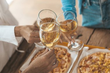 Beyaz şarap bardaklarını tokuşturan genç Asyalılar, yeni yıl partileri, yıllık şirket partileri, alkollü içecekler. Şirket çalışanları parti yemekleri, kutlamalar..