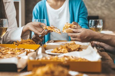 İnsanların yemek için tepside pizza toplamasını, yeni şirket partilerini, yeni yıl partilerini, şirket yıllık toplantılarını, alkollü içecekleri. Şirket çalışanları parti yemekleri, pizza kutlamaları..