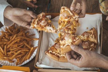 İnsanların yemek için tepside pizza toplamasını, yeni şirket partilerini, yeni yıl partilerini, şirket yıllık toplantılarını, alkollü içecekleri. Şirket çalışanları parti yemekleri, pizza kutlamaları..