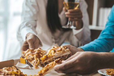 İnsanların yemek için tepside pizza toplamasını, yeni şirket partilerini, yeni yıl partilerini, şirket yıllık toplantılarını, alkollü içecekleri. Şirket çalışanları parti yemekleri, pizza kutlamaları..