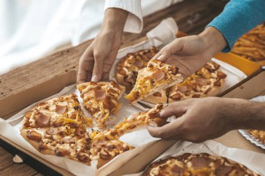 İnsanların yemek için tepside pizza toplamasını, yeni şirket partilerini, yeni yıl partilerini, şirket yıllık toplantılarını, alkollü içecekleri. Şirket çalışanları parti yemekleri, pizza kutlamaları..