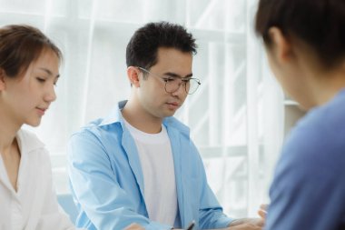 Yakın plan Asyalı bir adam bir grup insanla konuşuyor. İşadamları bir şirket kurmak için bir grup iş ortağıyla görüşüyor. Bir grup genç ve enerjik insan şirketi yönetecek..