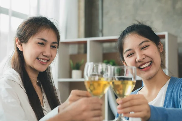 Group of young Asians clinking white wine glasses, startup company parties, New Year's parties, annual company parties, alcoholic beverages. Company employee party catering ideas, celebrations.