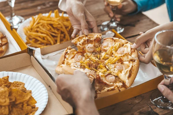 İnsanların yemek için tepside pizza toplamasını, yeni şirket partilerini, yeni yıl partilerini, şirket yıllık toplantılarını, alkollü içecekleri. Şirket çalışanları parti yemekleri, pizza kutlamaları..