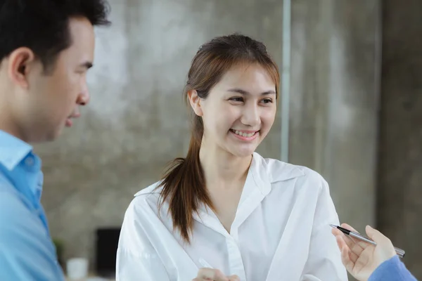 Close-up Asian woman talking to a group of people. Business women are meeting with a group of business partners to open a startup company, a group of young, energetic people to run the company.