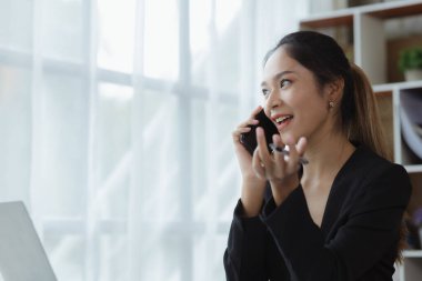 Telefonda konuşan Asyalı bir kadın, bir girişim şirketinde satış elemanı, ürün ve promosyon satmak için müşterileri arıyor. Telefon kanalları aracılığıyla ürün satma kavramı. 