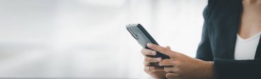 Cep telefonundan mali bilgilere bakan genç bir iş kadını, şirketin mali belgelerini kontrol ediyor, yeni kurulan bir şirketin kadın yöneticisidir. Mali yönetim kavramı.