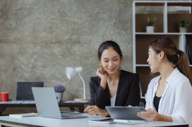 İki güzel Asyalı kadın şirket toplantı odasında buluşup iş planlarını geliştirme planlarını tartışıyorlar. İş görüşmesi fikri.