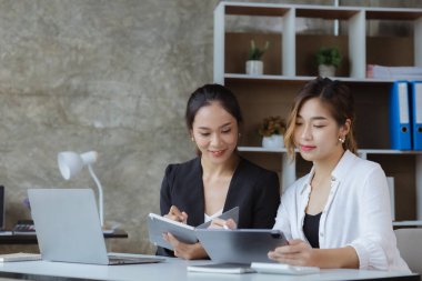 İki güzel Asyalı kadın şirket toplantı odasında buluşup iş planlarını geliştirme planlarını tartışıyorlar. İş görüşmesi fikri.