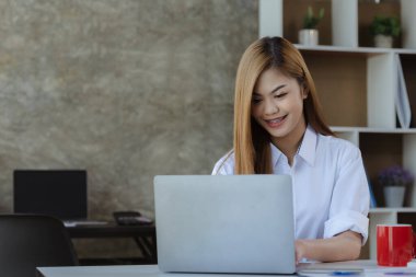 Dizüstü bilgisayarıyla yazı yazan güzel bir Asyalı kadın, genç ve enerjik bir iş adamı. Yeni jenerasyonun politikasıyla iş yapıyor..