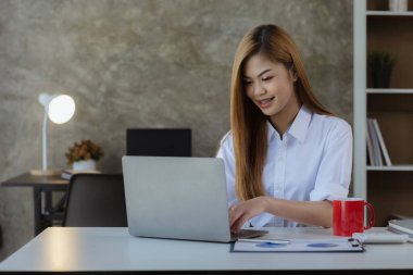 Dizüstü bilgisayarıyla yazı yazan güzel bir Asyalı kadın, genç ve enerjik bir iş adamı. Yeni jenerasyonun politikasıyla iş yapıyor..