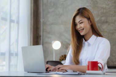 Dizüstü bilgisayarıyla yazı yazan güzel bir Asyalı kadın, genç ve enerjik bir iş adamı. Yeni jenerasyonun politikasıyla iş yapıyor..