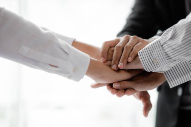 Three people put their fists together, businessmen joint venture start up companies, they are young entrepreneurs start up companies. up together to manage a plan to make the company profitable.