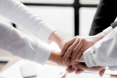 Three people put their fists together, businessmen joint venture start up companies, they are young entrepreneurs start up companies. up together to manage a plan to make the company profitable.