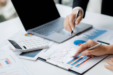 İki işadamı toplantı materyaline işaret ederek, ortak iş sorunlarını geliştirme ve çözme planında birlikte çalıştılar. Büyüme ve kalite için işletme yönetimi kavramı.