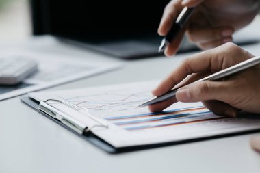 İki işadamı toplantı materyaline işaret ederek, ortak iş sorunlarını geliştirme ve çözme planında birlikte çalıştılar. Büyüme ve kalite için işletme yönetimi kavramı.