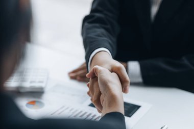 Close-up two business men holding hands, Two businessmen are agreeing on business together and shaking hands after a successful negotiation. Handshaking is a Western greeting or congratulation.