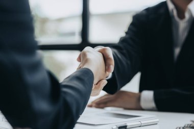 Close-up two business men holding hands, Two businessmen are agreeing on business together and shaking hands after a successful negotiation. Handshaking is a Western greeting or congratulation.