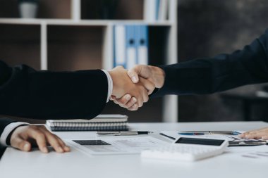 Yakın plan iki iş adamı el ele tutuşuyor, iki işadamı iş konusunda hemfikir ve başarılı bir pazarlıktan sonra el sıkışıyor. El sıkışmak Batının selamlaması ya da kutlamasıdır..