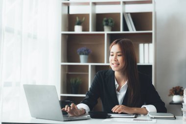 Business woman working in a private office, she is reviewing the company's financial documents sent from the finance department before he takes it to a meeting with a business partner. Financial concept.