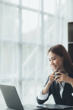 Business woman working in a private office, she is reviewing the company's financial documents sent from the finance department before he takes it to a meeting with a business partner. Financial concept.