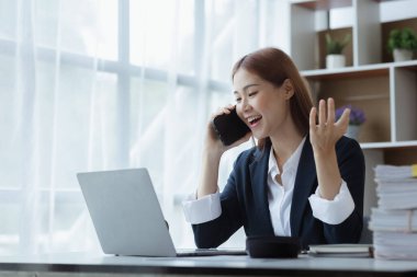 Telefonda konuşan Asyalı bir kadın, bir girişim şirketinde satış elemanı, ürün ve promosyon satmak için müşterileri arıyor. Telefon kanalları aracılığıyla ürün satma kavramı.