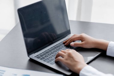 Laptop klavyesinde yazan bir kadın, bir internet alışveriş sitesinde sipariş vermek için kredi kartı bilgilerini dolduruyor. Çevrimiçi alışveriş ve kredi kartı ödeme kavramı.