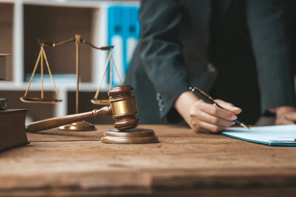 The judge's hammer is placed on the table, the lawyer concept assumes that the defendant defends the client in order to win the case or gain the greatest benefit in accordance with the law.