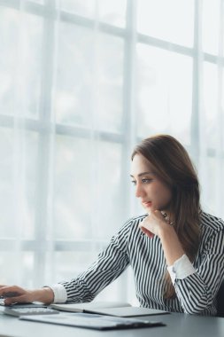 Bir iş kadını şirketin mali belgelerini kontrol ediyor ve bir mesajlaşma programı aracılığıyla finans müdürüyle konuşmak için dizüstü bilgisayar kullanıyor. Şirket mali yönetimi kavramı.