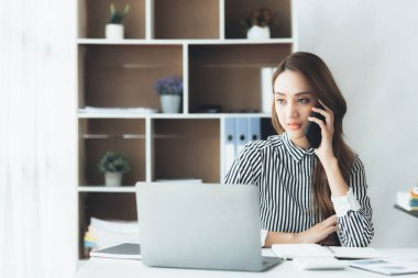 Telefonda konuşan Asyalı bir kadın, bir girişim şirketinde satış elemanı, ürün ve promosyon satmak için müşterileri arıyor. Telefon kanalları aracılığıyla ürün satma kavramı.