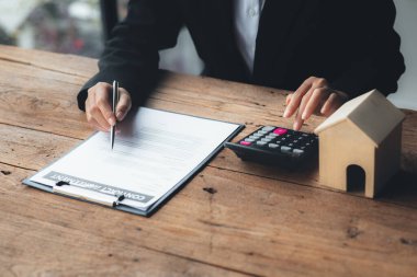 A rental company employee is calculating the cost for the customer to agree to sign a rental contract, explaining the rental terms and conditions. Home and real estate rental ideas.