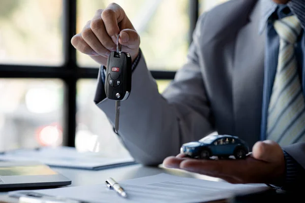 Sprzedawca Samochodów Wręcza Klientowi Klucz Omówieniu Szczegółów Podpisaniu Umowy Kupna — Zdjęcie stockowe