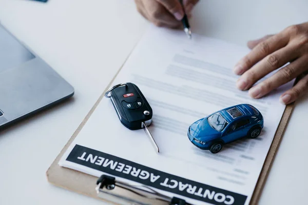 The salesperson is explaining the details of the purchase contract to the customer before agreeing to the contract, selling the car, selling the car at a major dealer. Vehicle sales concept.