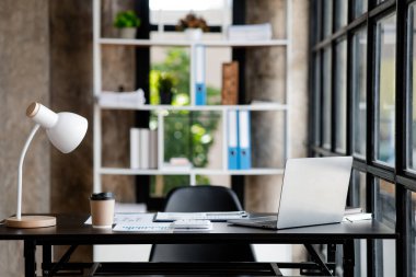 Modern çatı katı tarzı ofis odası, dizüstü bilgisayarı ve kahve fincanı olan bir masa, şirket ofisindeki boş ofis. Ofis odasını düzenleme fikri.