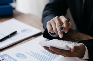 Bir kadın finansör şirketin mali belgelerini inceliyor. Finans departmanından aylık hesap özeti. Şirketin doğruluk ve büyüme finansmanını yönetme kavramı.