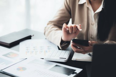 İş kadını cep telefonundan mali bilgilere bakıyor, şirketin mali belgelerini kontrol ediyor, yeni kurulan bir şirketin kadın yöneticisidir. Mali yönetim kavramı.