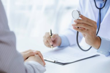 Doktorlar hastane muayene odalarındaki hastalar üzerinde steteskop kullanırlar, uzmanların hastalıklarını tedavi ederler ve orada tedavi ederler. Tıbbi tedavi ve uzman kavramları.