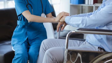 Doktor, hastanenin muayene odasındaki hastayı cesaretlendirmek için koluna dokunur, hastalığı bir tıp uzmanından tedavi eder ve anında tedavi eder. Tıbbi tedavi kavramları.