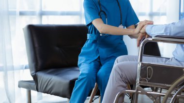 Doktor, hastanenin muayene odasındaki hastayı cesaretlendirmek için koluna dokunur, hastalığı bir tıp uzmanından tedavi eder ve anında tedavi eder. Tıbbi tedavi kavramları.