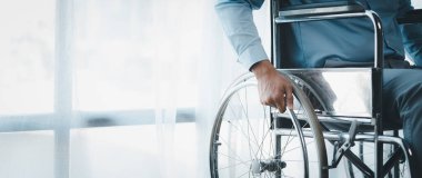 Man sitting on a wheelchair, man with a wheelchair at company office, recruiting people with disabilities to work, working with a team in the company and having a disabled person as part of the team.