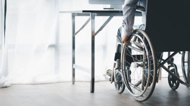 Man sitting on a wheelchair, man with a wheelchair at company office, recruiting people with disabilities to work, working with a team in the company and having a disabled person as part of the team.