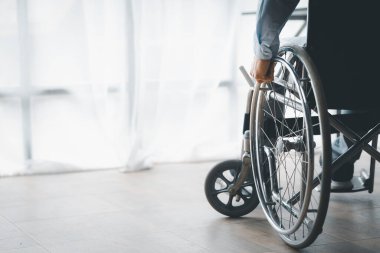 Tekerlekli sandalyede oturan, şirket ofisinde tekerlekli sandalyesi olan, engelli insanları işe alan, şirketteki bir ekiple çalışan ve engelli bir insanı ekibin bir parçası yapan bir adam..