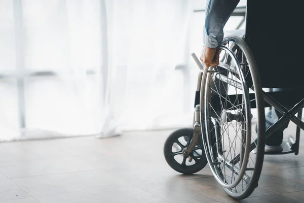 Man sitting on a wheelchair, man with a wheelchair at company office, recruiting people with disabilities to work, working with a team in the company and having a disabled person as part of the team.